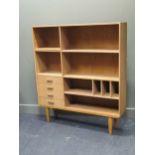 A modern wall cabinet comprising four drawers, pigeonholes and adjustable shelves, raised on four