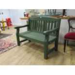 A green painted garden bench 94 x 123 x 62cmProvenance:Landwade Hall, Exning, Suffolk