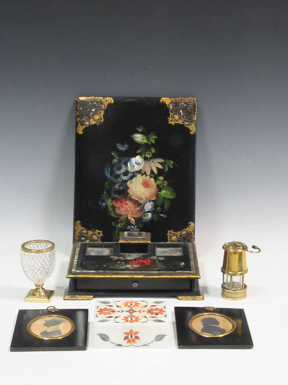 A Victorian papier-mache desk set, two silhouettes, a miniature miners lamp and a gilt metal mounted