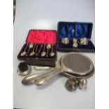 A collection of silverware including flatware, a cased three-piece condiment set, silver backed