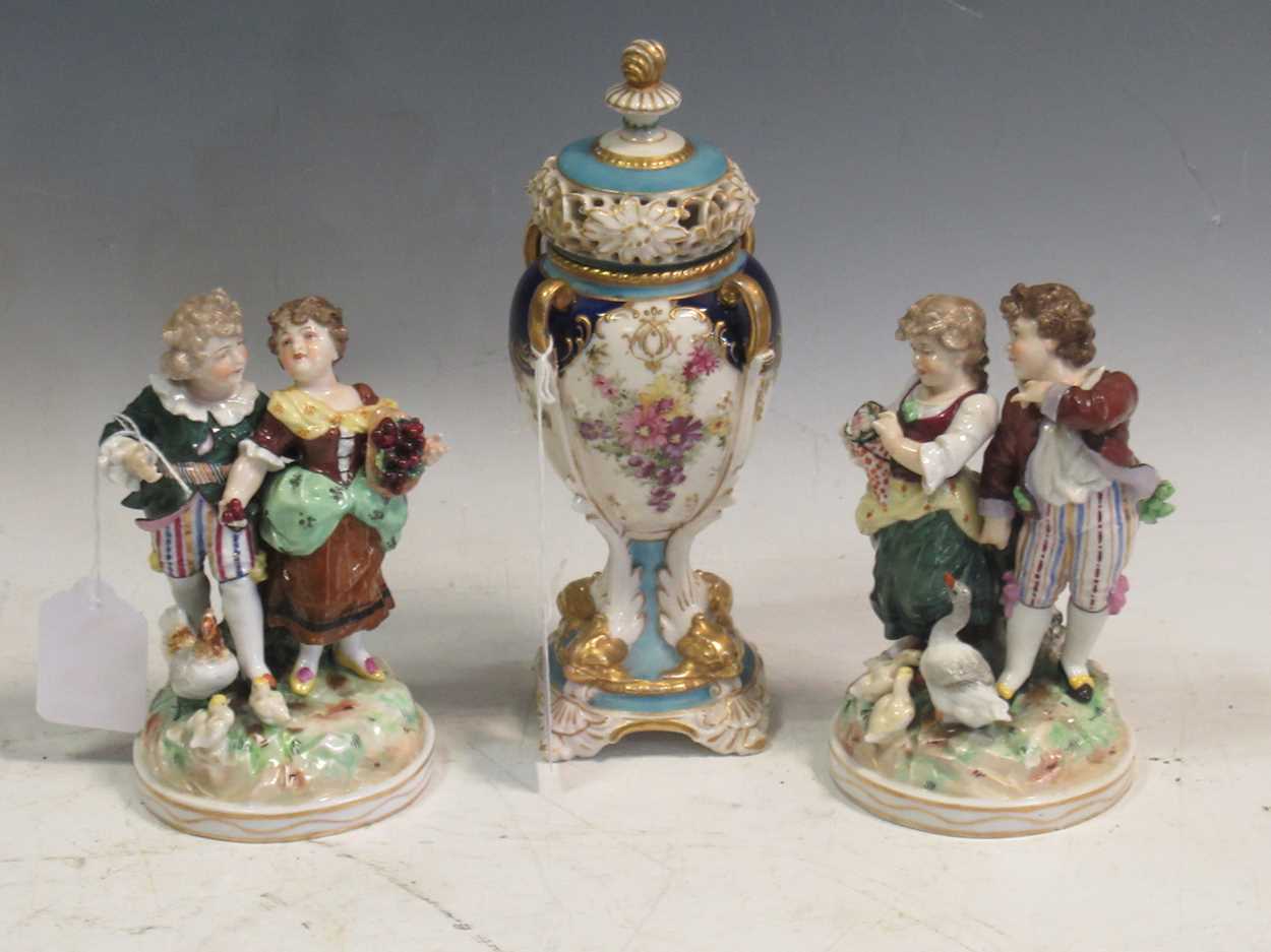 A pair of continental porcelain figurines in Meissen style and a continental porcelain vase and