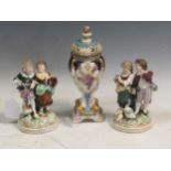 A pair of continental porcelain figurines in Meissen style and a continental porcelain vase and