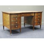 An Edwardian mahogany and inlaid desk comprising of nine drawers on square tapered legs and brass