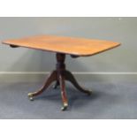 A George IV mahogany tilt top breakfast table, the rounded rectangular top above a turned support on