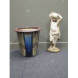 A cast iron garden statue and a glazed garden pot