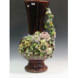 A large floor standing glazed earthenware vase with relief moulded floral decoration