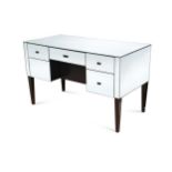 A contemporary mirrored dressing table, with central frieze drawer flanked by two further drawers to