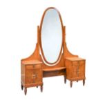 A French Art Deco burr walnut dressing table, circa 1925, with central oval mirror flanked by