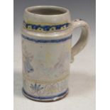 An 18th century Delft pottery polychrome tankard, decorated with a dancing couple, 18.5cm high (