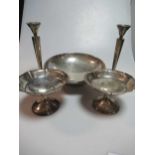 An American metalwares silver bowl, two bon bon dishes and two candlesticks, all loaded and all