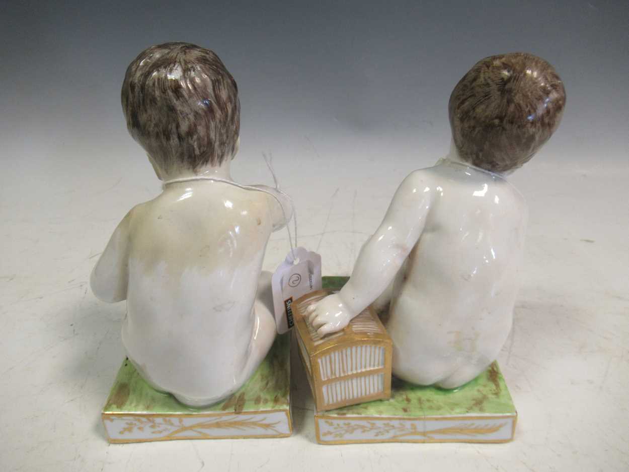 A pair of Meissen bookends, modelled as seated cherubs, the rectangular bases mounted with cages, - Bild 5 aus 7