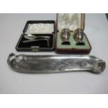 Two silver ashtrays, a cased silver spoon and pusher, a cased pair of silver pepperettes, a silver