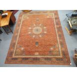 A modern orange ground carpet with central floral medalion 362 x 276cm