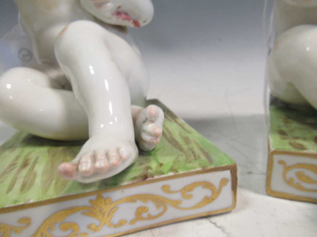 A pair of Meissen bookends, modelled as seated cherubs, the rectangular bases mounted with cages, - Bild 3 aus 7