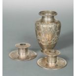 A 20th century Iranian metalwares vase together with a pair of dwarf candlesticks,