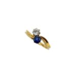 A two stone sapphire and diamond crossover style ring,
