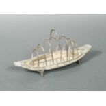 A George V silver seven bar toast rack with integral crumb tray,