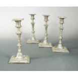 A set of four early George III 18th century cast silver candlesticks,
