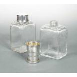 A pair of glass spirit flasks with silver plated novelty caps,