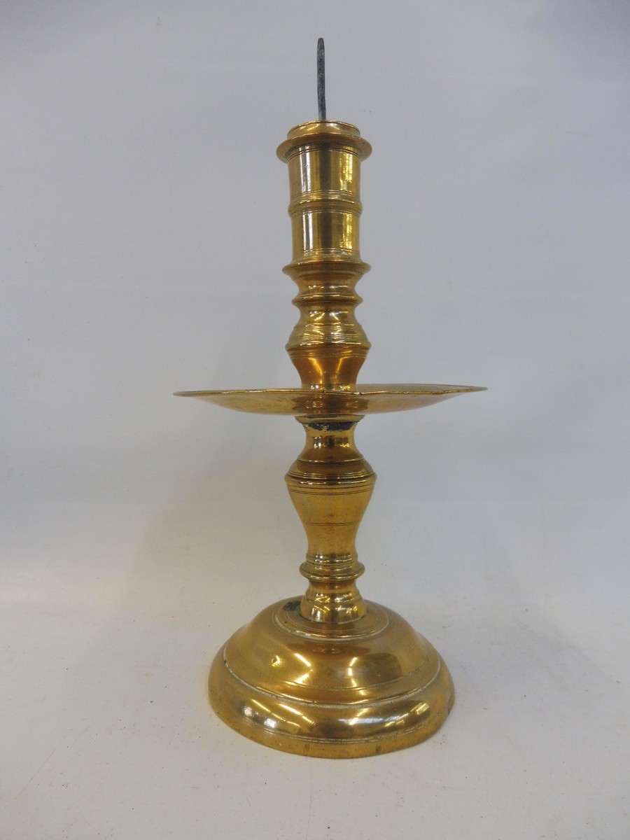 A 17th Century Dutch West Indies brass pricket candlestick with a broad mid drip pan, 11" long.