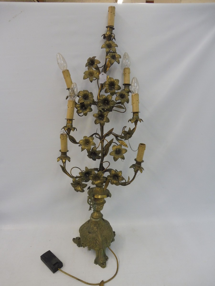 A tall brass table lamp centrepiece in the form of an entwined plant with flowers, raised upon a