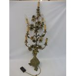 A tall brass table lamp centrepiece in the form of an entwined plant with flowers, raised upon a