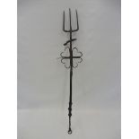 A 17th Century wrought iron downhearth fork with intgral trivet, 29 1/2" long.