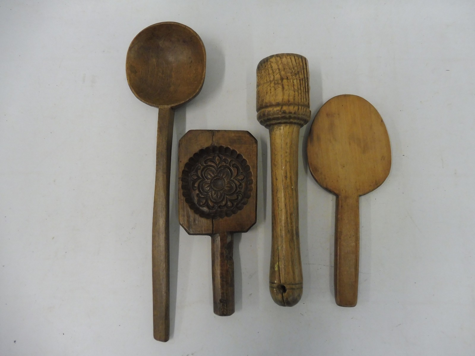 A quantity of 19th Century treen kitchen implements including a fruitwood butter stamp.