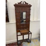 An Arts and Crafts oak hallstand, unusually with panelled back above a single glove drawer, 30" w