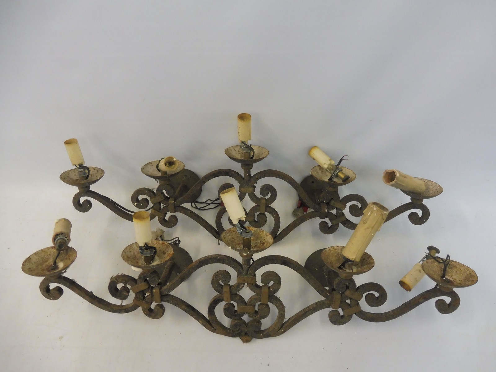 A pair of five branch wrought iron wall lights.