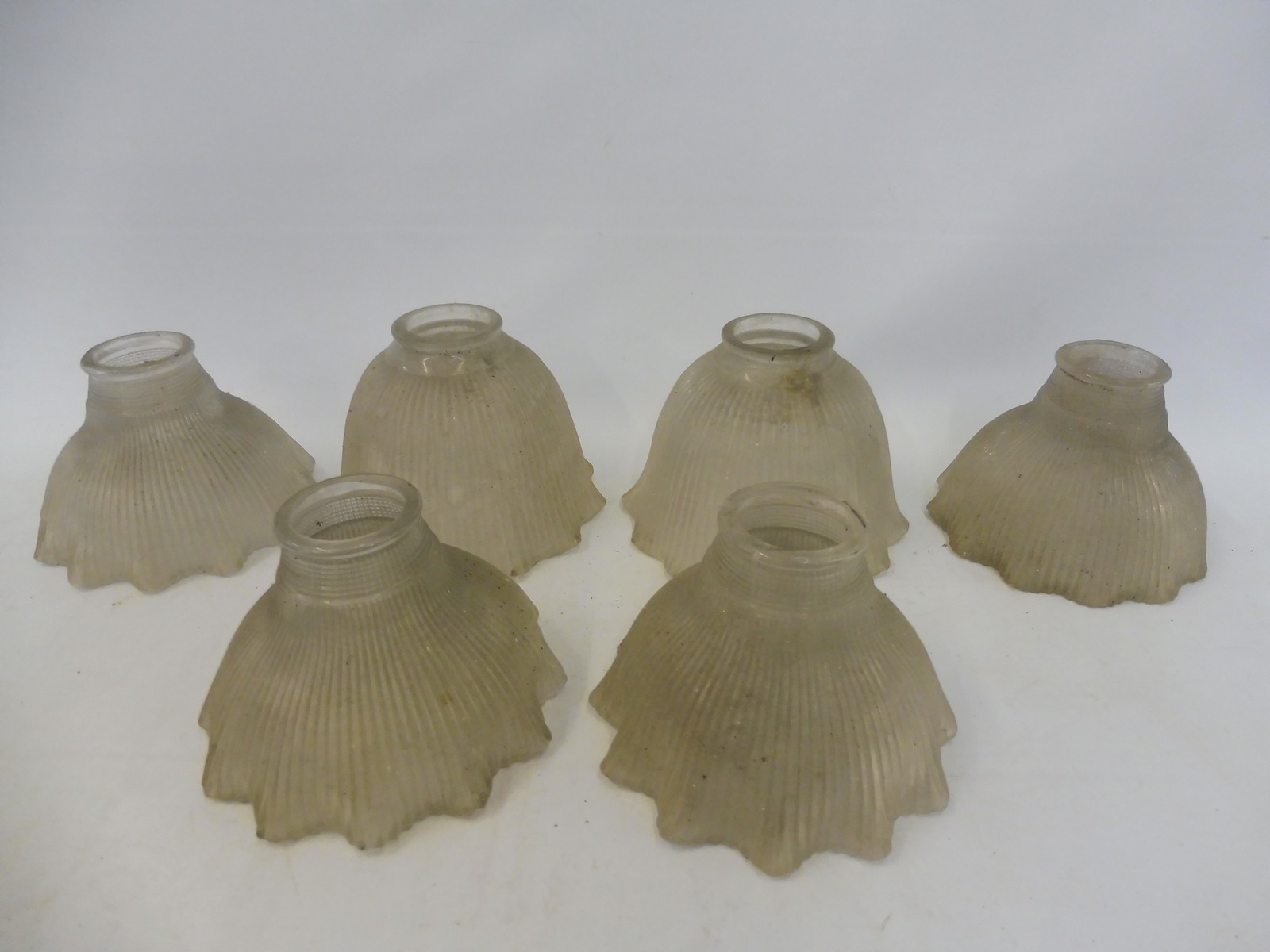 Four matching ribbed glass lamp shades with flared rims and two similar.