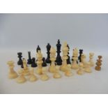 A chess set, one ivory piece replaced with a wooden example.