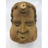 A large and unusual Folk Art stylised carved wooden mask, a male character with scrolled curly hair,