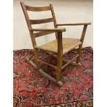 An Arts and Crafts 'Shaker' pine and rush seated rocking chair.