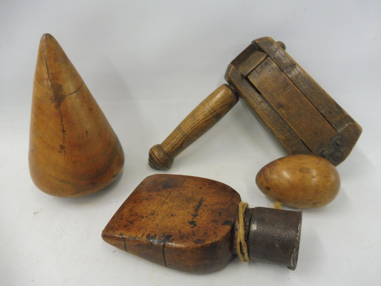 A Victorian ash bird scarer, a sailor's fruitwood sail rubber, a lignum turnpin and a treen egg.