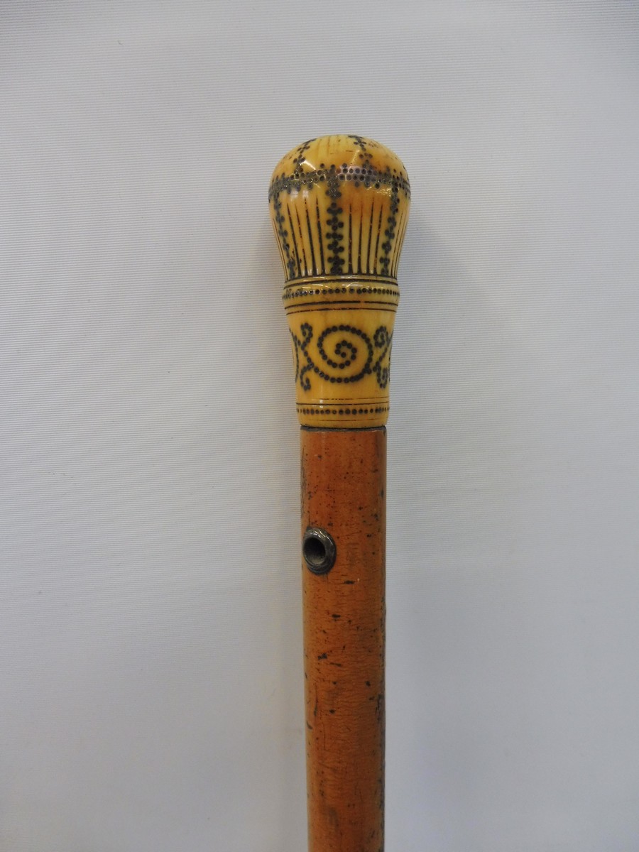 A malacca walking cane with a steel inlaid ivory knop.