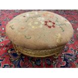 An early 19th Century giltwood circular stool with floral embroidered top.