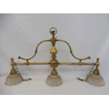 A brass three division light fitting with fluted flared shades.