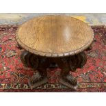 A good quality oak circular occasional table raised upon three boldly carved mythical creature