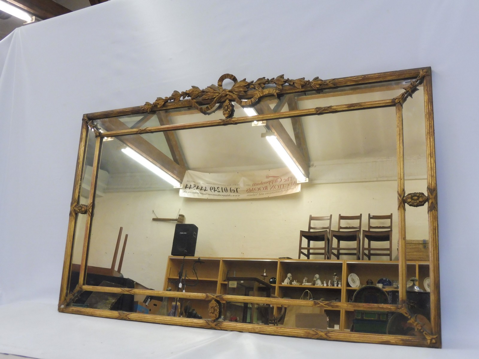 A 19th Century gilt framed border glass wall mirror with leaf and bow design pediment, depository