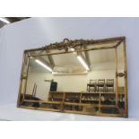 A 19th Century gilt framed border glass wall mirror with leaf and bow design pediment, depository