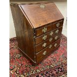 An 18th Century mahogany bureau on squat bun feet, lacking glazed upper section, with good fitted