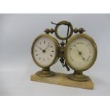 A 19th Century Continental oval clock and aneroid barometer in brass cases mounted together on a