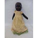 A black headed doll with material limbs.