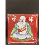 An Oriental enamel sign, decorated with a seated Buddha.