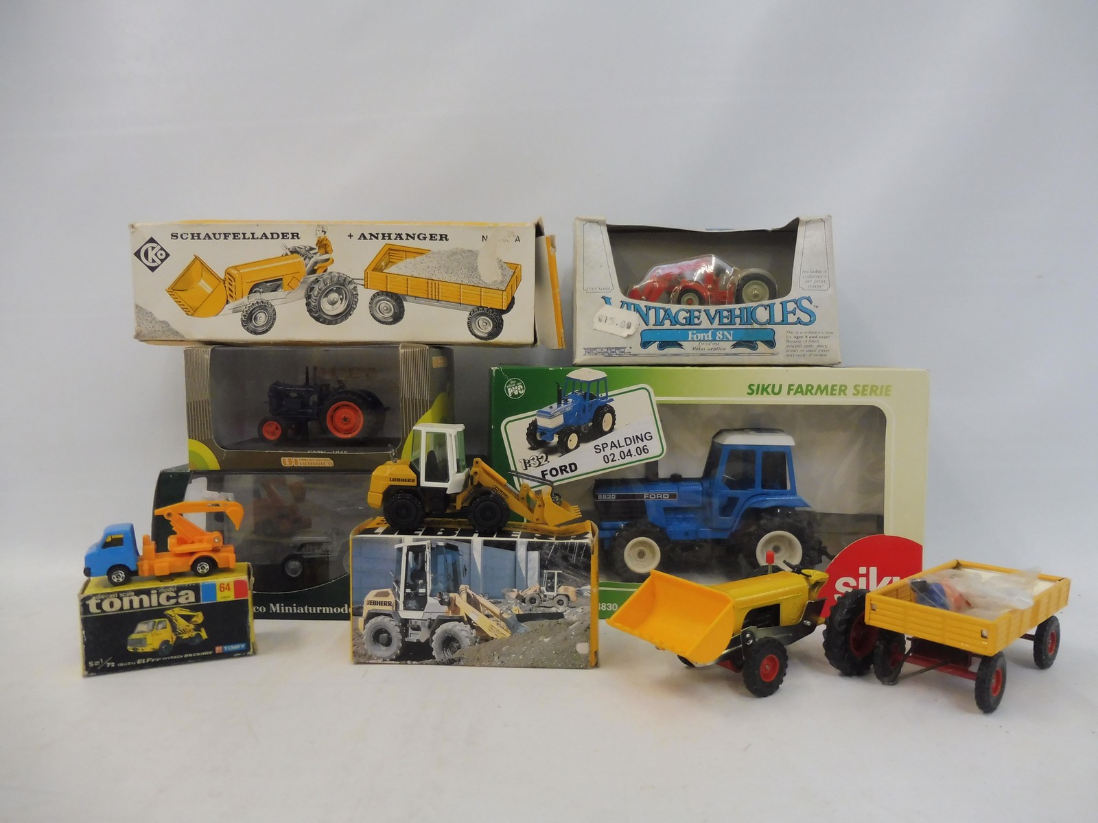 A selection of boxed agricultural tractors, different scales and models to include Siku, Tomica