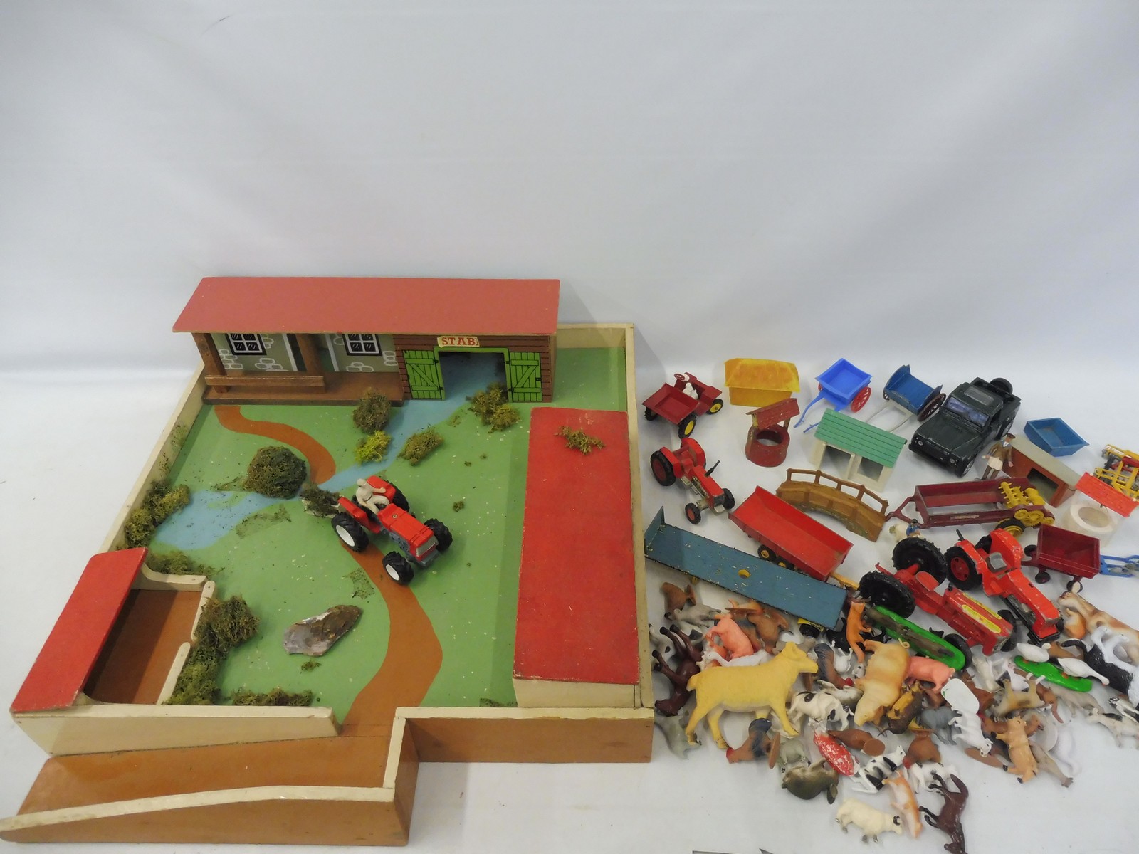 A collection of agricultural vehicles, farm animals and buildings.