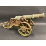 A table top model of a canon, bronze barrel on an iron carriage, approx. 18" long.