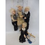 Four porcelain headed string puppets, one being a musician.