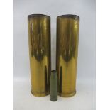 A pair of tall brass 105mm shell cases, plus an empty 25mm round.